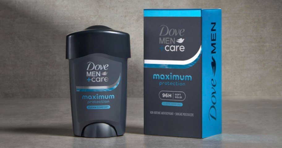 Dove Men+Care deodorant stick and box on a gray surface. Packaging is dark blue and teal, featuring the text "maximum protection" and "clean comfort."