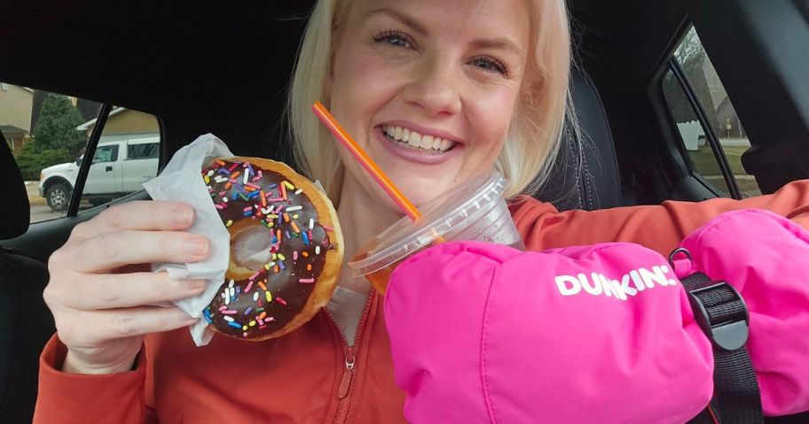 woman holding dunkin donut and drink with pink glove