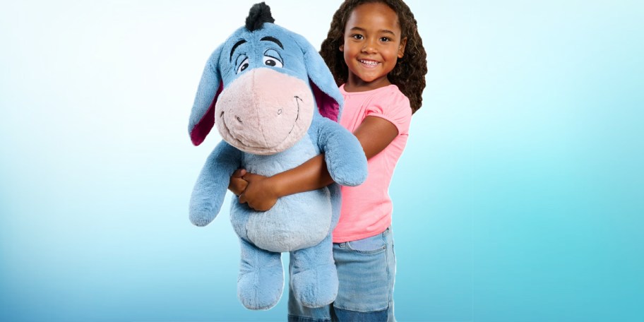 girl holding eeyore plush 