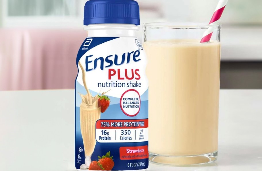 ensure strawberry shake next to cup on table