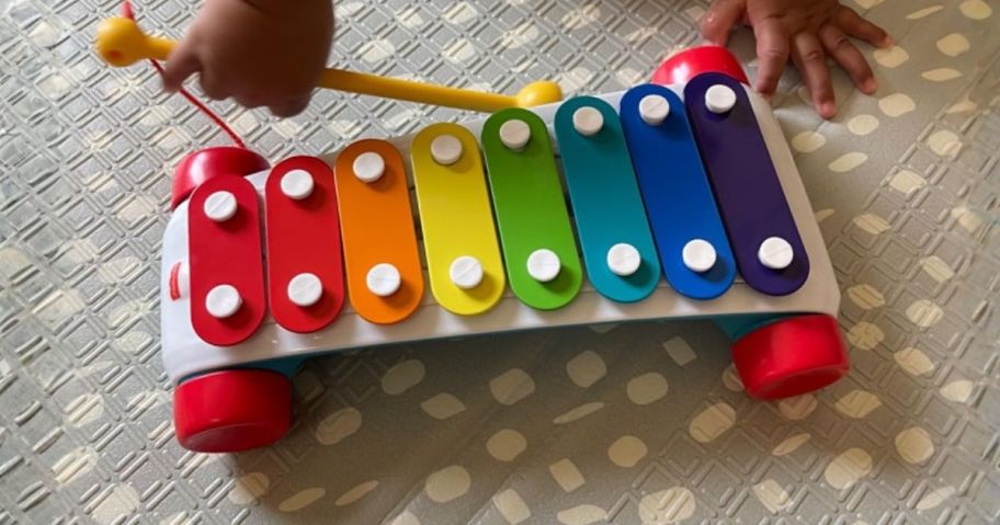 baby playing with Fisher-Price Toddler Pull Toy on floor