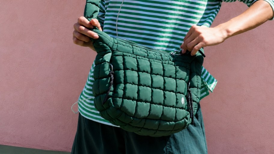 a woman carrying a green quilted cross body bag
