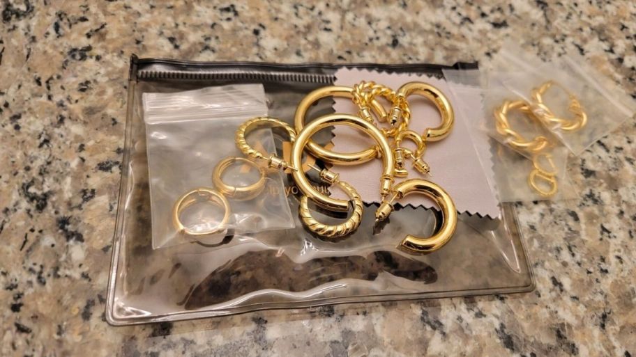 several pair of glod plated earrings in different styles and sizes. 