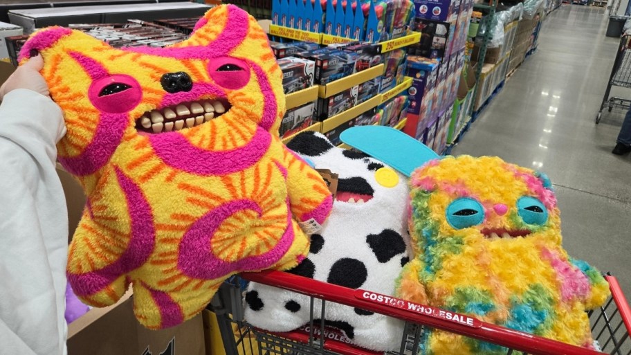 womans hand holding a plush with oddly human looking teeth