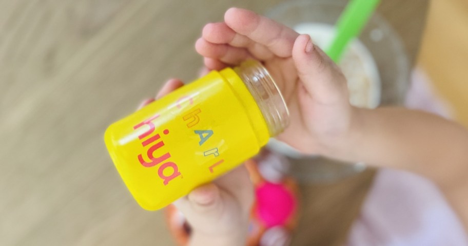 kids hands holding a bottle of Hiya Kids Vitamins