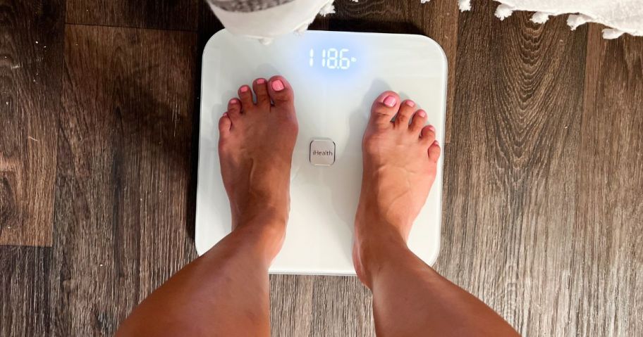 Woman's feet standing on a digital scale