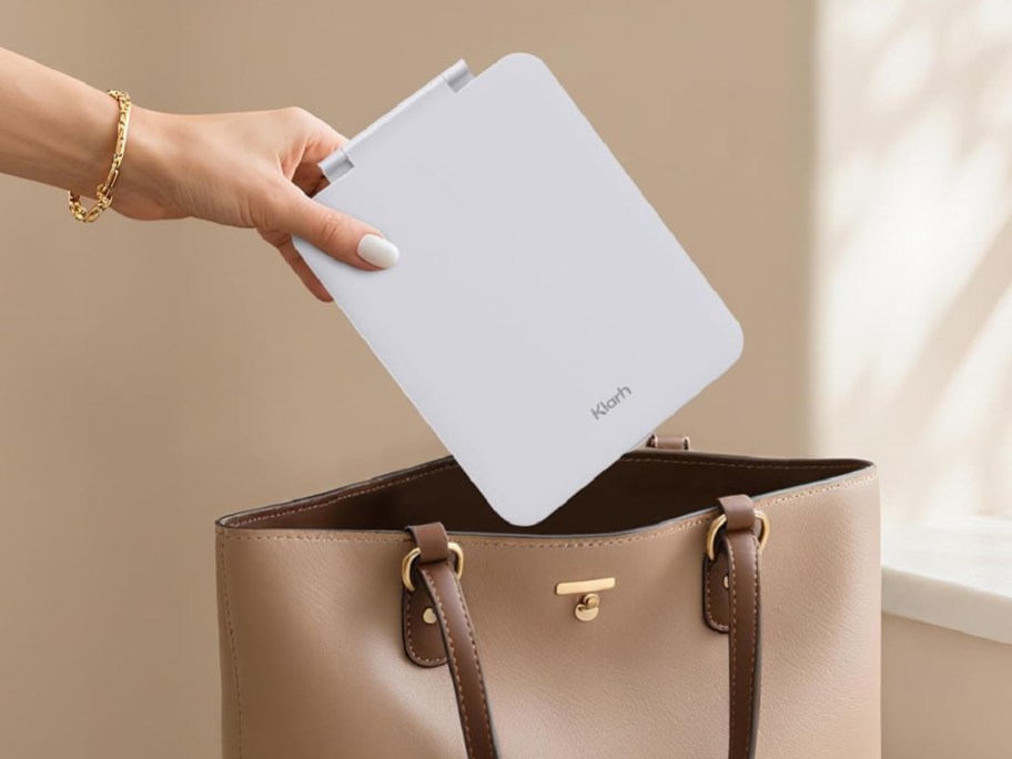 woman putting a klarh Travel Makeup Mirror in a bag
