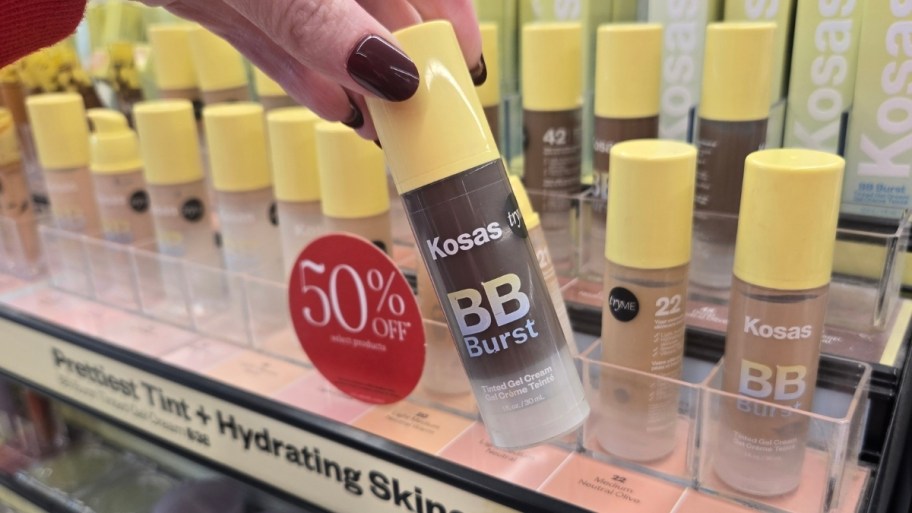 a hand holding a bottle of Kosas bb cream
