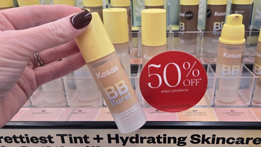 a hand holding a bottle of Kosas bb cream