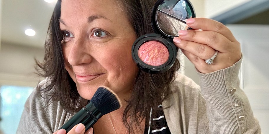 woman holding blush with brush 