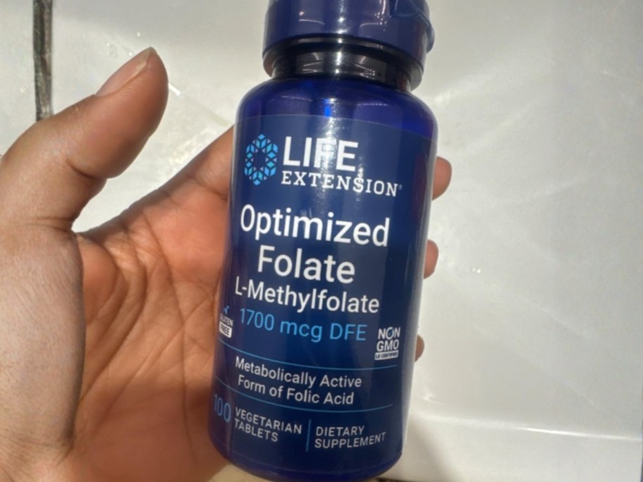 hand holding a bottle of life extension folate vitamins