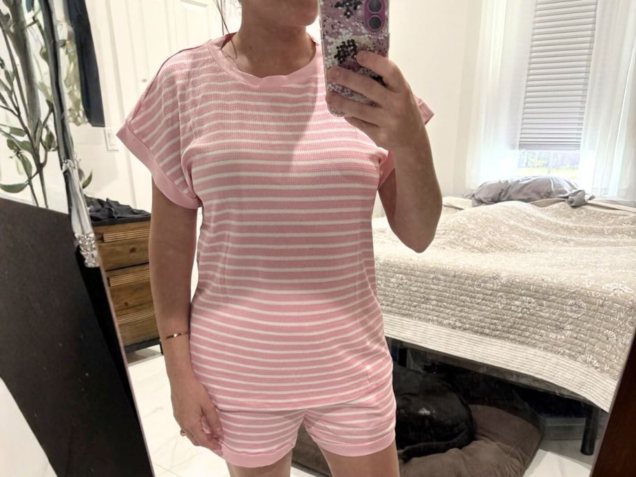 woman wearing striped lounge set and taking selfie