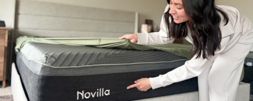 Woman pointing to a label on a mattress.