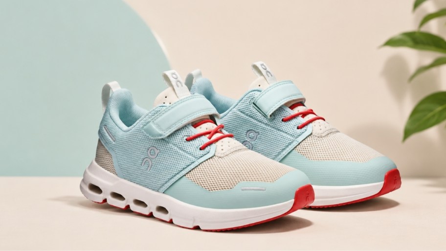 a pair of on kids cloud shoes in aqua and white