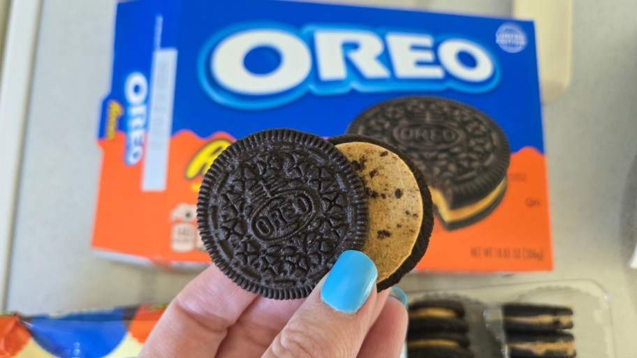 womans hand holding a reeses oreo cookie