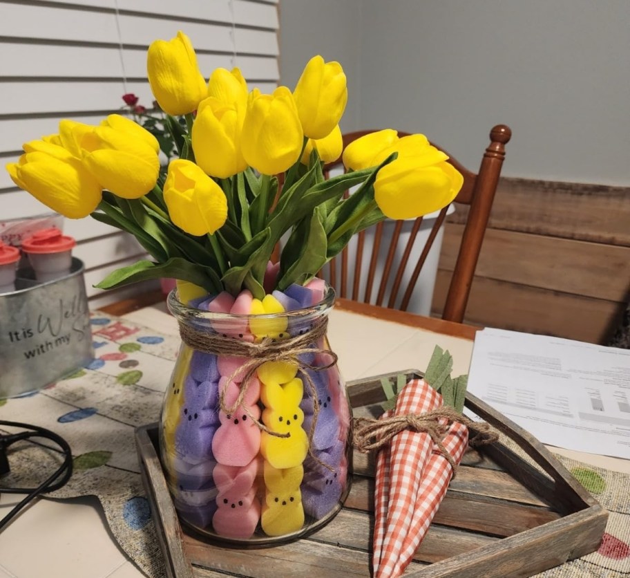 vase on a table filled with yellow tulips and peeps vase filler