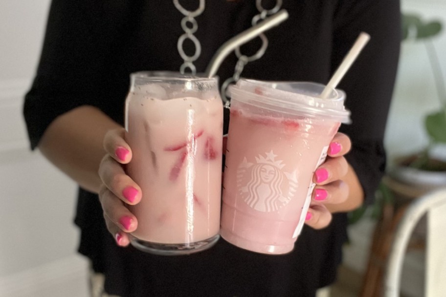 hands holding two pink drinks