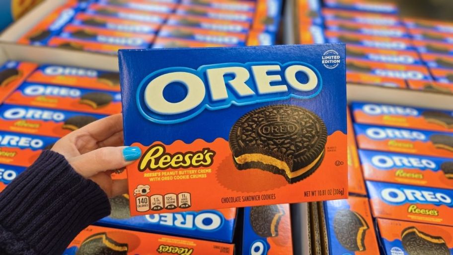 womans hand holding a reeses oreo cookies box