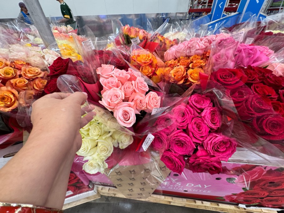 Hands touching a bouquet of roses in a store
