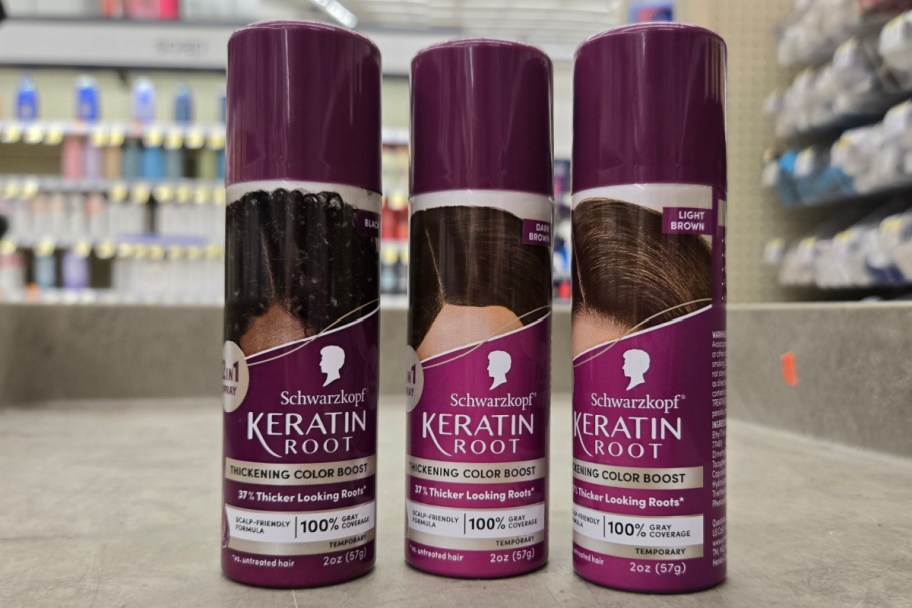 three purple root spray cans