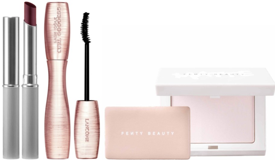 A collection of makeup products displayed on a white background, including a dark lipstick in a silver tube, a rose-gold Lancôme mascara with its wand, a small pink Fenty Beauty compact, and a white Fenty Beauty compact.