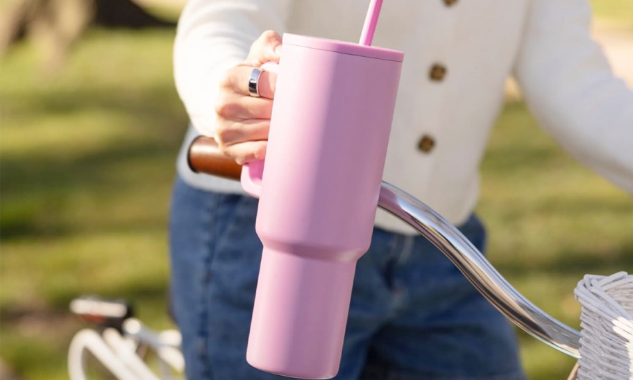 hand holding pink tumblers