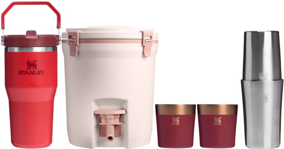 A set of Stanley drinkware and cooler featuring a red tumbler, pink cooler with spout, red cups with copper rims, and sleek silver shaker.