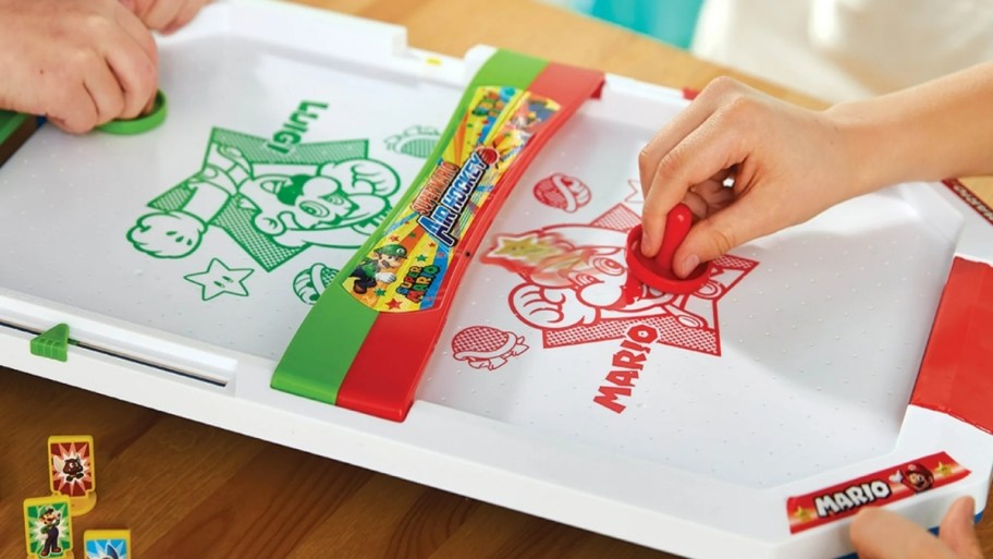 two kids playing with a super mario air HOCKEY table 