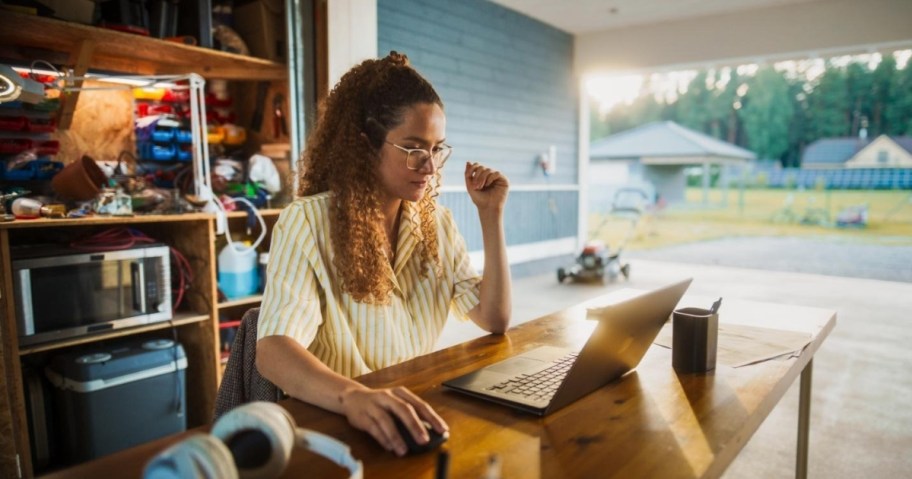 woman using a laptop on a desk in her garage