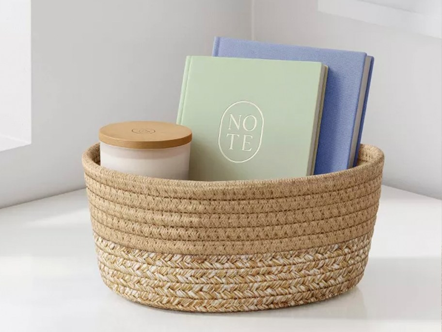 brown basket full of notebooks and candle 