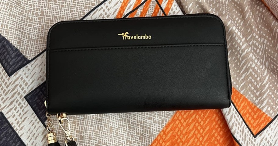 a black wristlet displayed on a colorful scarf