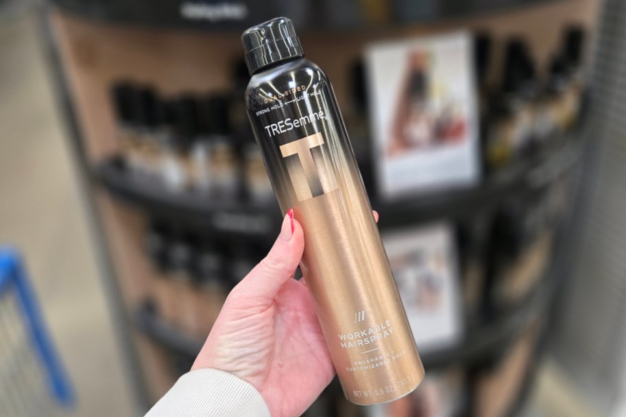 hand holding hairspray bottle in store
