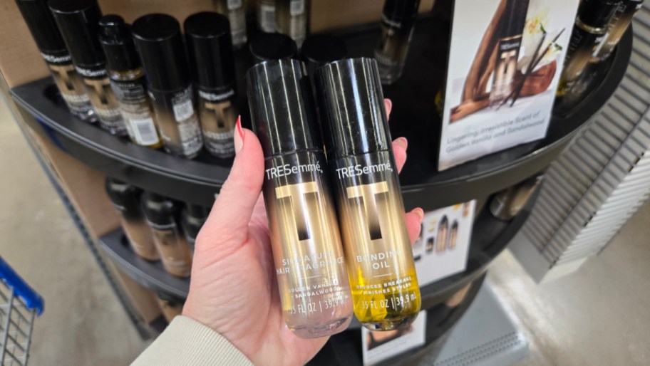 hand holding bottle of hair fragrance and bonding oil