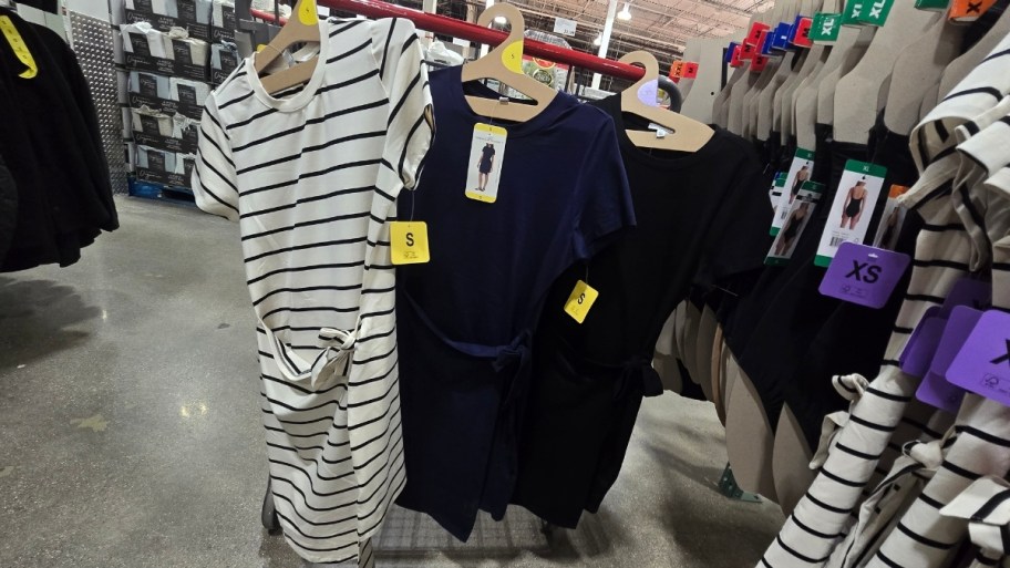 3 womens t-shirt dressed hanging on the side of a shopping cart