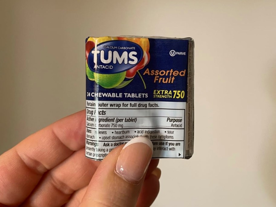 holding a travel size package of tums