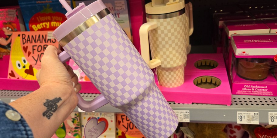 hand holding purple checkered tumbler 