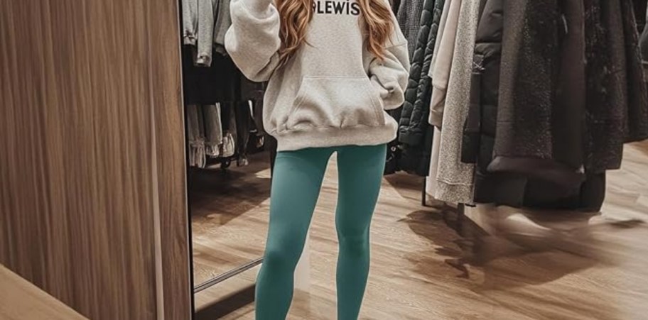 a woman in green leggings and a sweatshirt