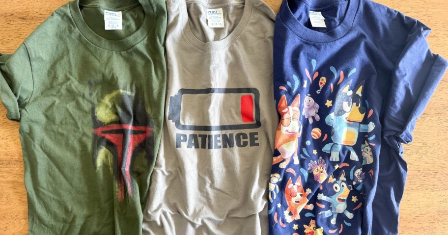 three graphic tees laid out