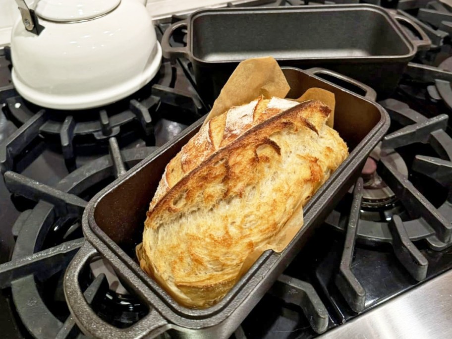 bread inside a cast iron loaf pan on stove