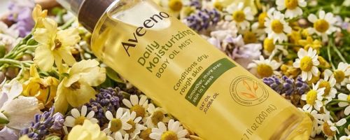 Aveeno Daily Moisturizing Body Oil Mist 6.7oz Bottle laying on flowers
