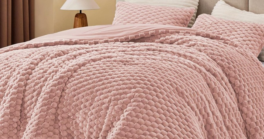 pink fuzzy comforter set on a bed