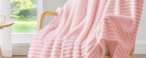 pink ribbed throw blanket draped over a chair