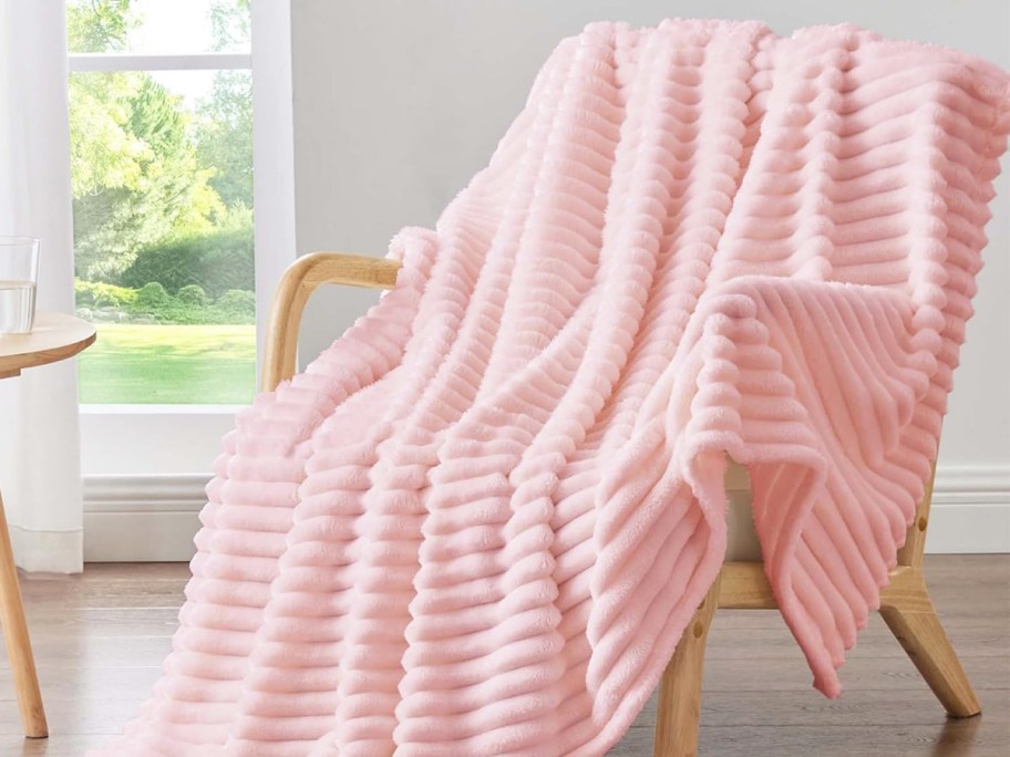 pink ribbed throw blanket draped over a chair