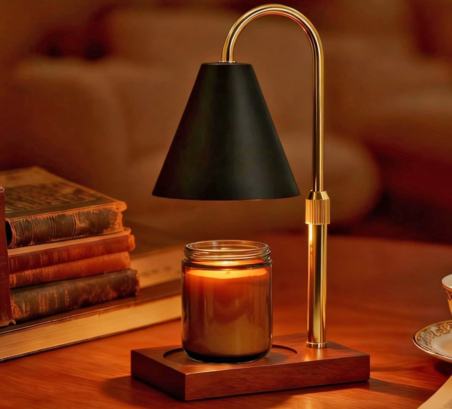 jar candle under a black and gold warming lamp