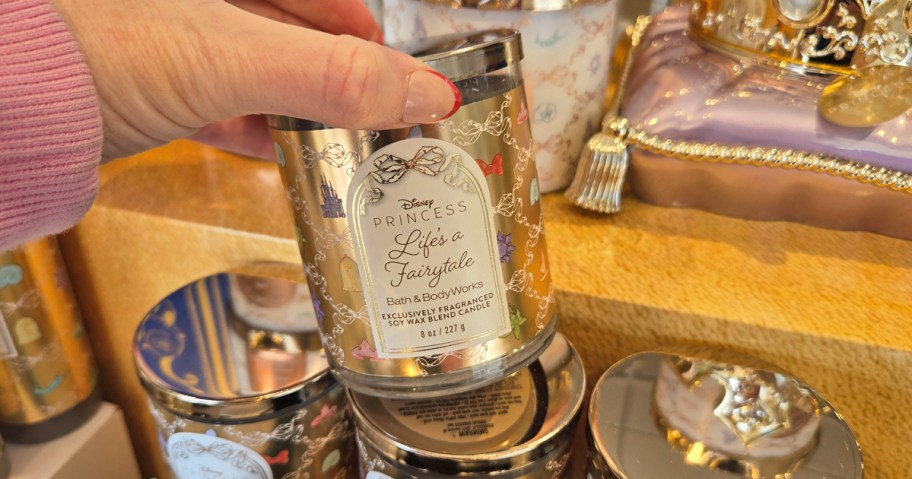 hand holding a gold disney princess single wick candle