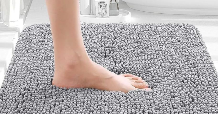 Gray Bathroom rugwith foot stepping on it