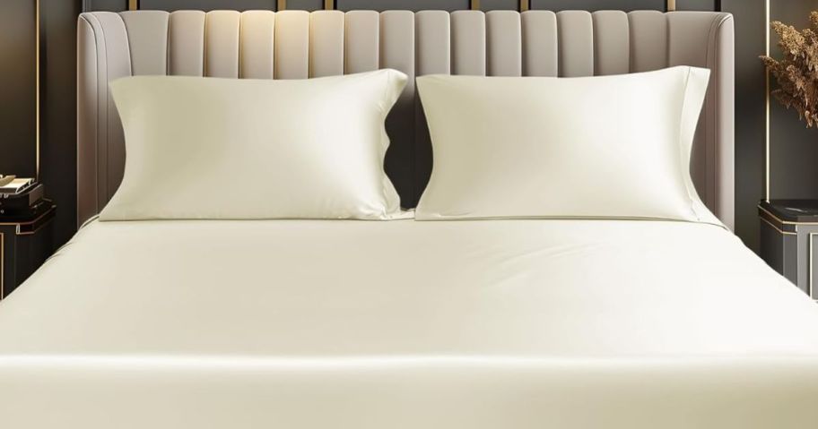 Bedelite Satin Sheets in cream color on a bed