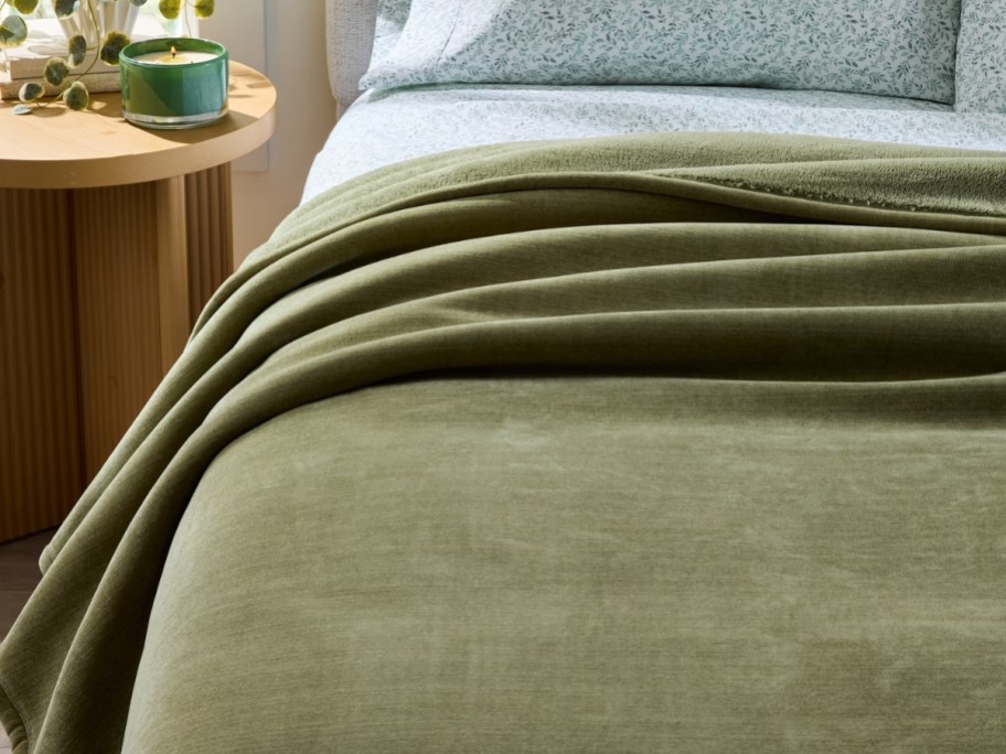 a bed with a green blanket on it