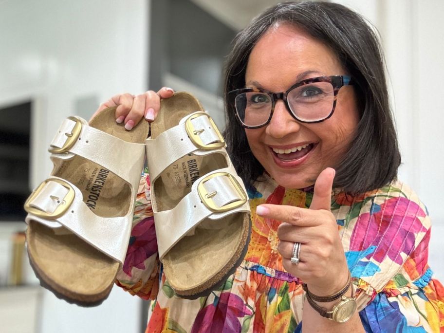 Woman holding a pair of Birkenstock Arizona Big Buckle sandals