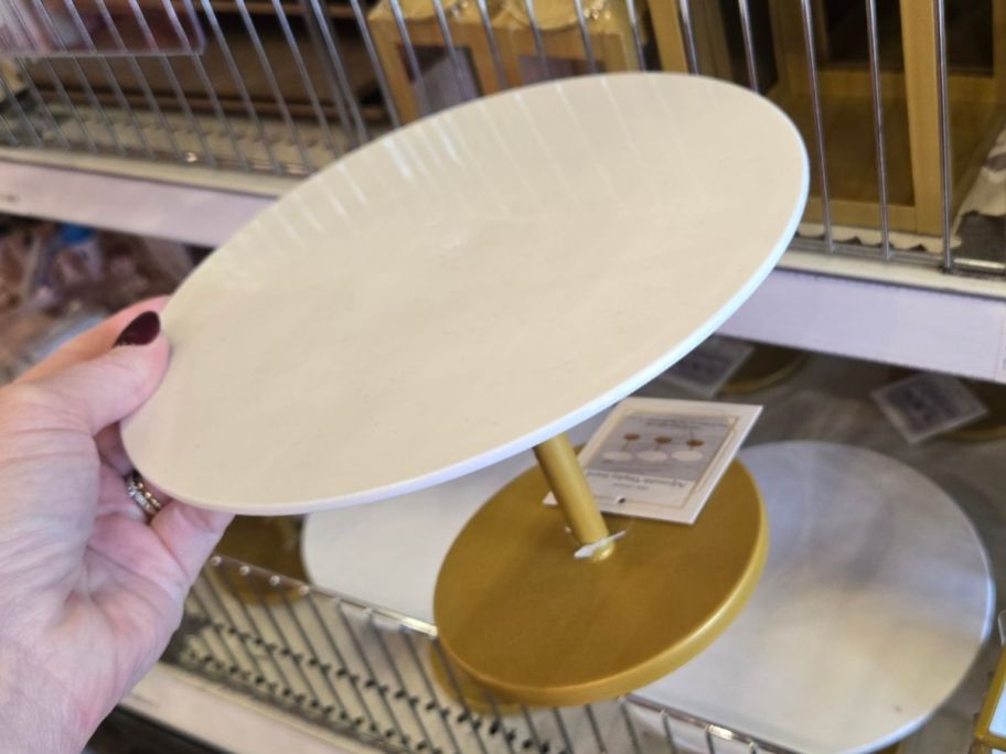 Hand holding an Adjustable Display Stand from Target's Bullseye's Playground